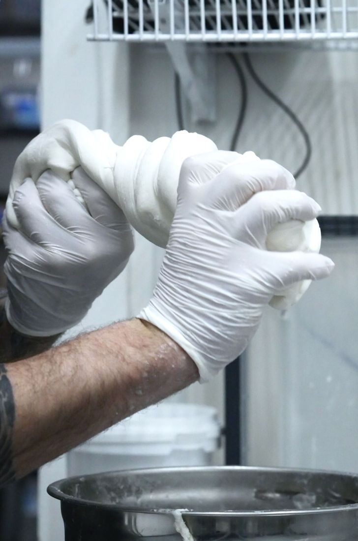 Gloved hands working a batch in the kitchen